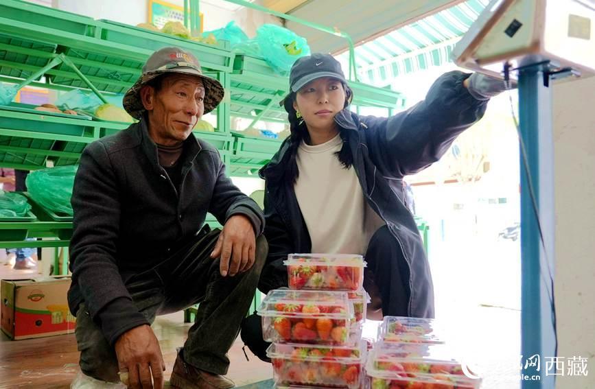 普琼（左一）把包装好的草莓送往销售点。人民日报记者 琼达卓嘎摄
